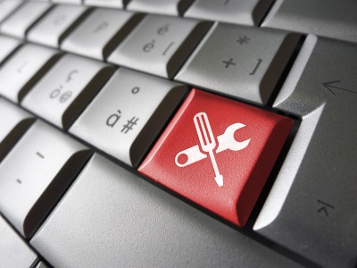 Computer repair service concept with work tools icons and symbol on a red laptop computer key for website and online business.
